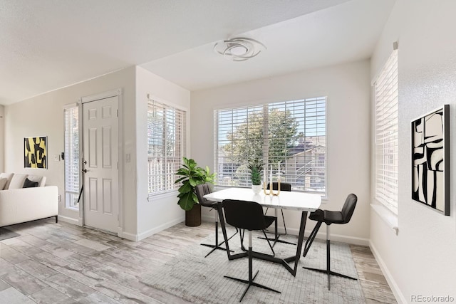 dining room featuring light wood finished floors and baseboards