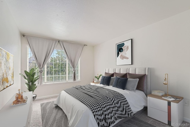 bedroom with a textured ceiling, carpet floors, and baseboards