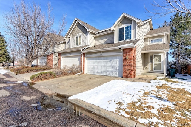 view of front facade with driveway, brick siding, an attached garage, and a shingled roof