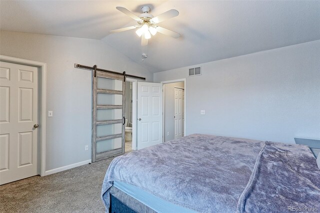 carpeted bedroom featuring lofted ceiling, ceiling fan, a barn door, connected bathroom, and visible vents