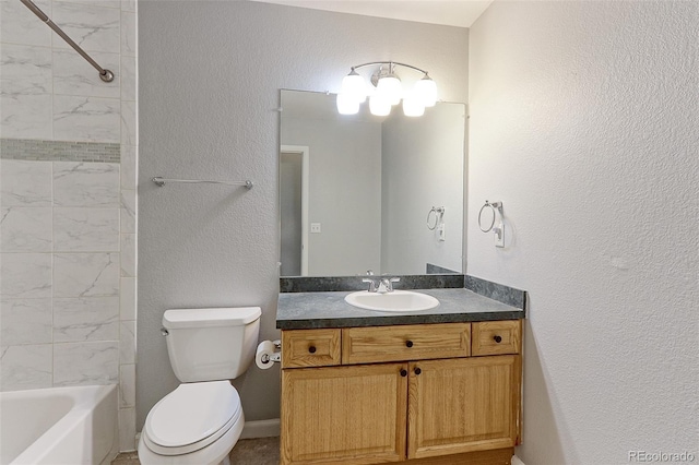 bathroom featuring toilet, a textured wall, shower / washtub combination, and vanity