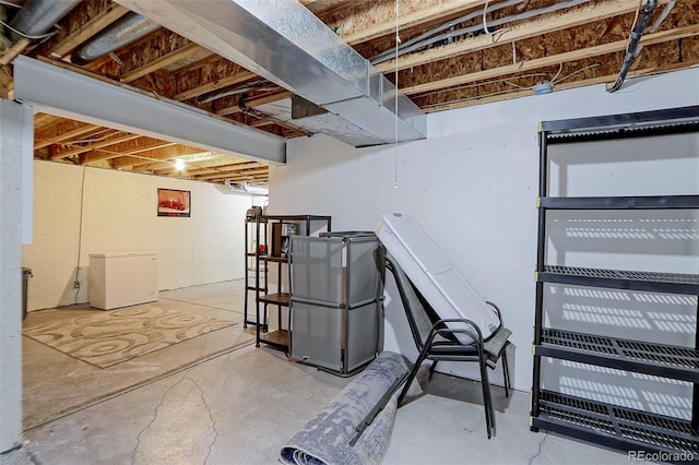 unfinished basement featuring fridge