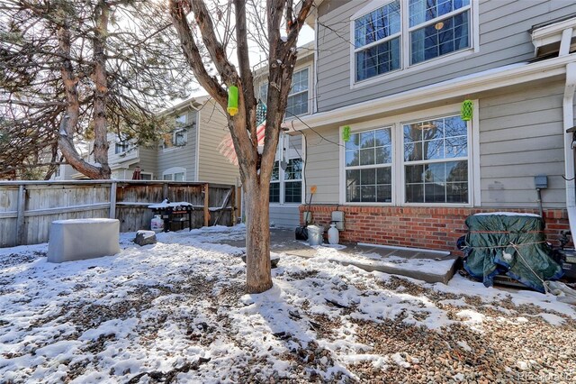 exterior space featuring brick siding and fence