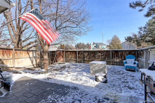 yard layered in snow with a fenced backyard