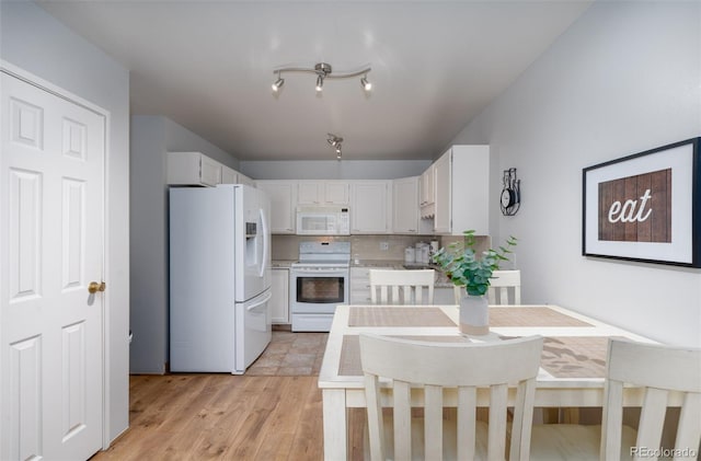 kitchen with light countertops, light wood-style flooring, decorative backsplash, white cabinetry, and white appliances