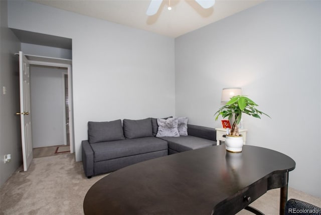 living area with light colored carpet and ceiling fan