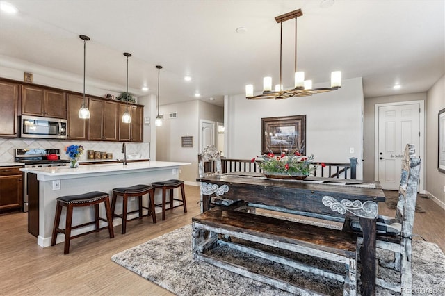 2012 Sagerock Dr, Castle Pines, CO 80108 - dining room featuring light wood-style flooring, a chandelier, and recessed lighting