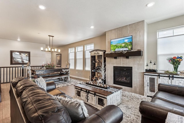 2012 Sagerock Dr, Castle Pines, CO 80108 - living room with a chandelier, wood finished floors, a tiled fireplace, and recessed lighting