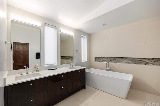 3057 S University Cir, Englewood, CO 80113 - bathroom with a freestanding bath, double vanity, tile patterned floors, lofted ceiling, and tile walls