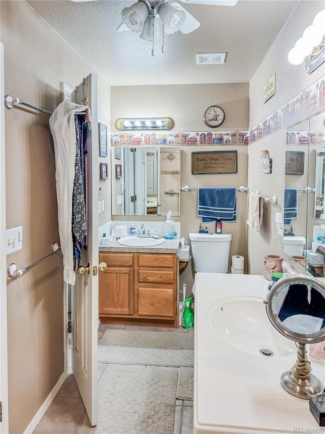 bathroom featuring toilet, a textured ceiling, vanity, ceiling fan, and tile patterned flooring