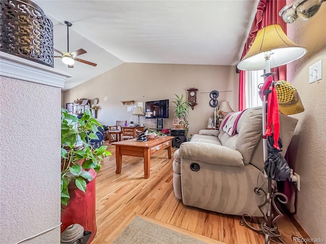 living room featuring hardwood / wood-style flooring, vaulted ceiling, and ceiling fan