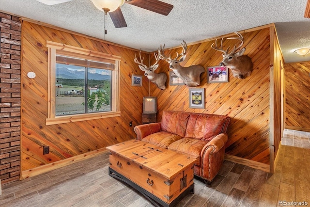 11679 US Highway 50, Howard, CO 81233 - living area with a textured ceiling, a ceiling fan, wood finished floors, and wooden walls