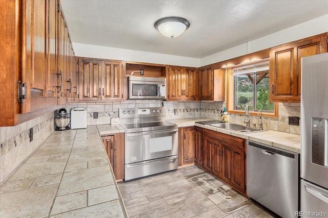 11679 US Highway 50, Howard, CO 81233 - kitchen with appliances with stainless steel finishes, a sink, tile counters, and brown cabinets