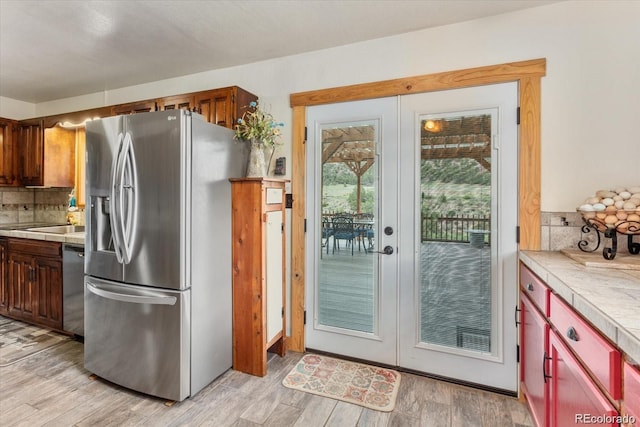 11679 US Highway 50, Howard, CO 81233 - kitchen with stainless steel appliances, french doors, backsplash, tile countertops, and light wood-style flooring
