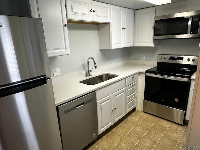 kitchen with appliances with stainless steel finishes, white cabinetry, and sink