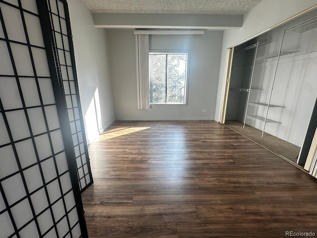 unfurnished bedroom with dark wood-type flooring, a closet, and a textured ceiling