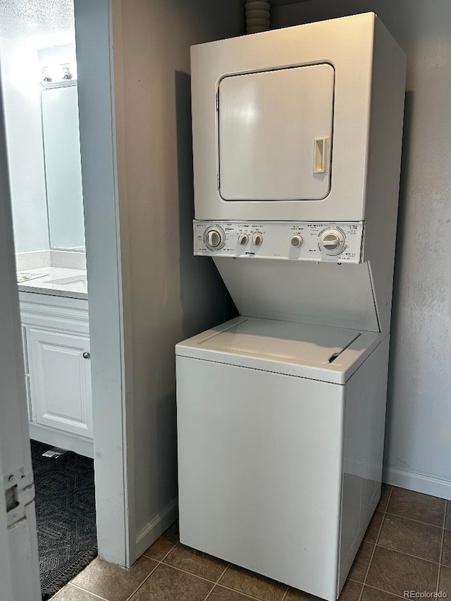 laundry room featuring tile patterned flooring and stacked washer / drying machine