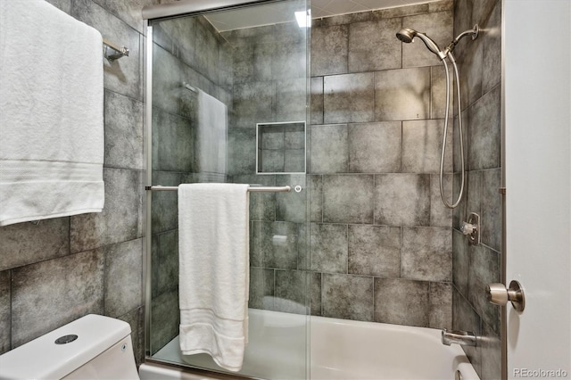 bathroom featuring combined bath / shower with glass door and toilet