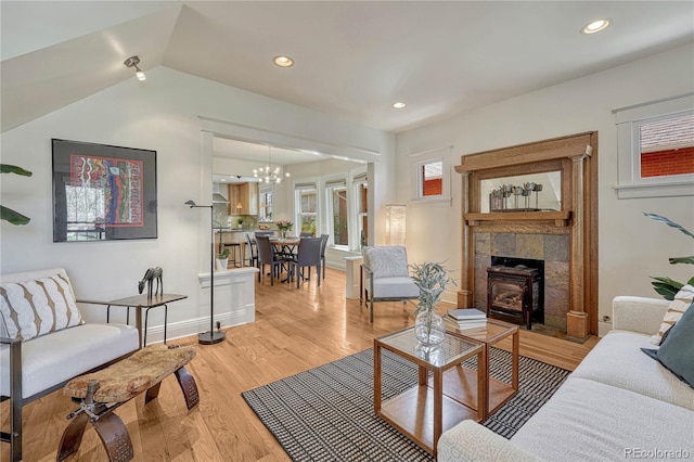 living area featuring a notable chandelier, light wood finished floors, recessed lighting, baseboards, and vaulted ceiling