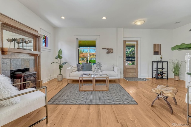 living area featuring baseboards, recessed lighting, wood finished floors, and a wealth of natural light