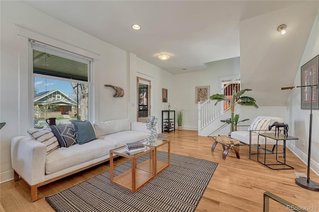 living room with baseboards, stairs, and wood finished floors