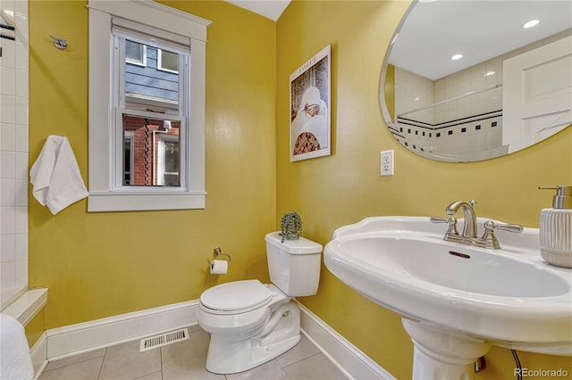 full bathroom featuring tile patterned flooring, toilet, baseboards, visible vents, and tiled shower