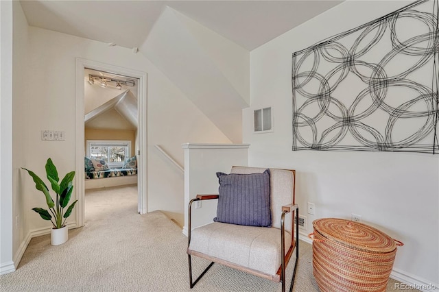 living area with visible vents, vaulted ceiling, baseboards, an upstairs landing, and carpet flooring