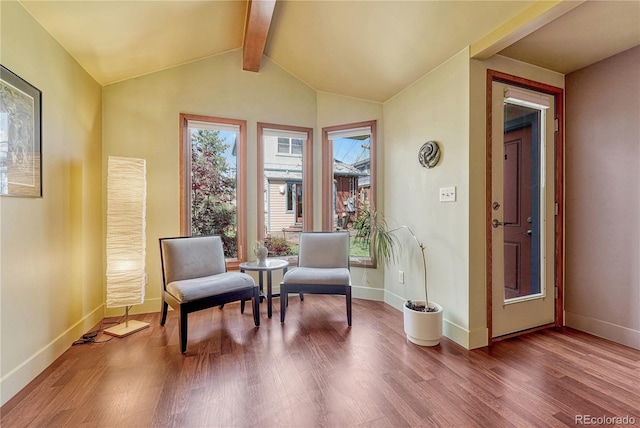 sitting room featuring baseboards, lofted ceiling with beams, and wood finished floors