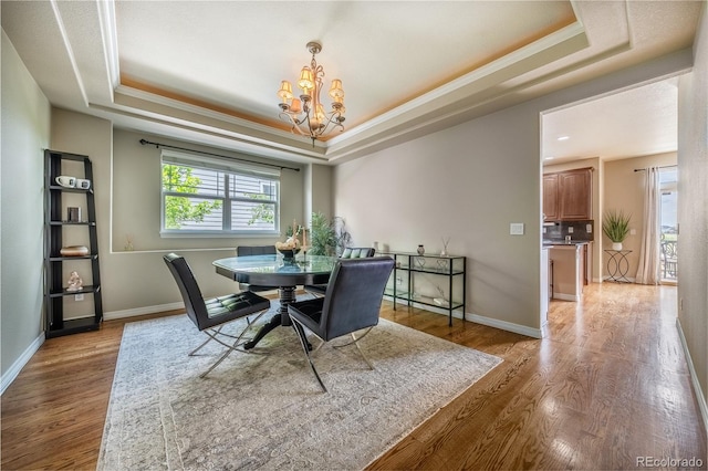 26741 E Arbor Dr, Aurora, CO 80016 - dining area with a tray ceiling, a chandelier, wood finished floors, crown molding, and baseboards