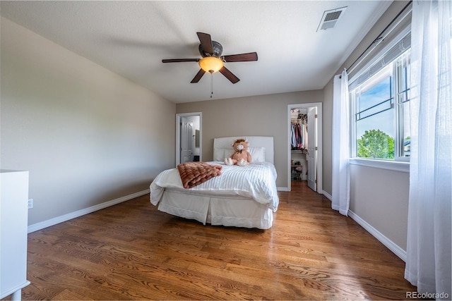26741 E Arbor Dr, Aurora, CO 80016 - bedroom with a spacious closet, wood finished floors, baseboards, a closet, and ceiling fan