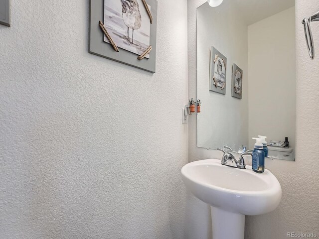 17991 E 103rd Ave, Commerce City, CO 80022 - bathroom featuring a sink and a textured wall