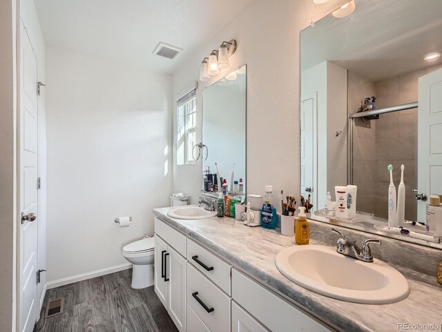 17991 E 103rd Ave, Commerce City, CO 80022 - full bathroom with a shower stall, toilet, wood finished floors, double vanity, and baseboards