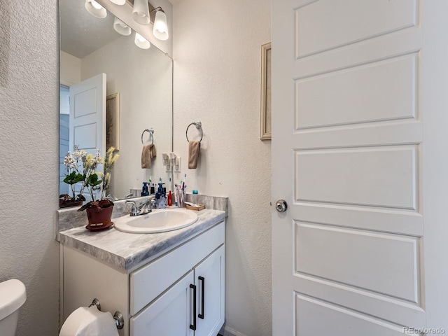 17991 E 103rd Ave, Commerce City, CO 80022 - bathroom featuring vanity, a textured wall, and toilet