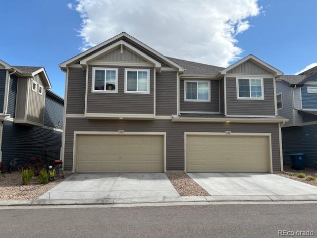 17991 E 103rd Ave, Commerce City, CO 80022 - view of front of home with driveway, an attached garage, and board and batten siding