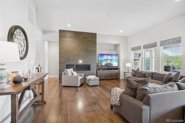 living room with hardwood / wood-style floors and a tiled fireplace