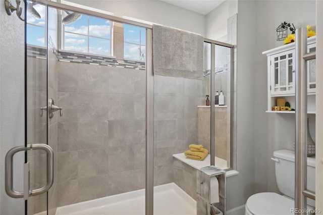 bathroom with an enclosed shower and toilet