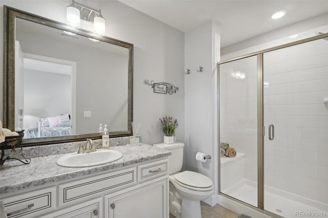 bathroom with tile patterned floors, vanity, toilet, and a shower with door