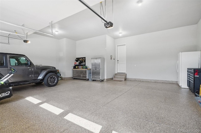 garage with white refrigerator and a garage door opener