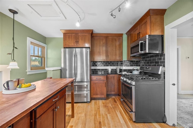 1601 Albion St, Denver, CO 80220 - kitchen featuring stainless steel appliances, brown cabinets, light wood-type flooring, tasteful backsplash, and butcher block counters