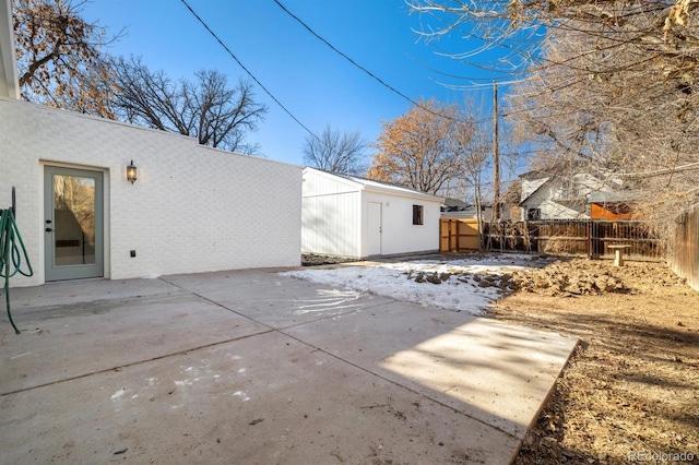 rear view of house featuring a patio, an outdoor structure, and fence