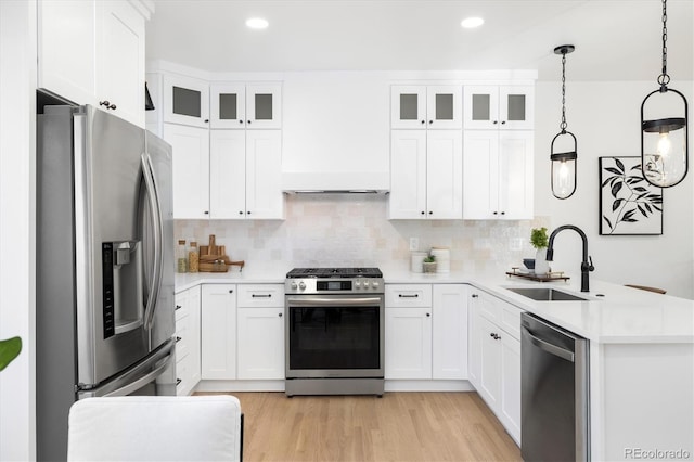 kitchen featuring stainless steel appliances, white cabinetry, and pendant lighting