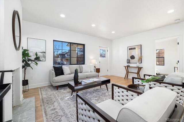 living room with recessed lighting, baseboards, and light wood finished floors