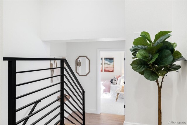 stairs with wood finished floors and baseboards