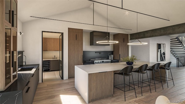 kitchen with sink, a kitchen breakfast bar, light hardwood / wood-style flooring, and hanging light fixtures