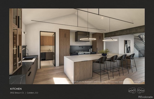 kitchen featuring lofted ceiling, hanging light fixtures, a kitchen bar, light hardwood / wood-style flooring, and stainless steel range oven