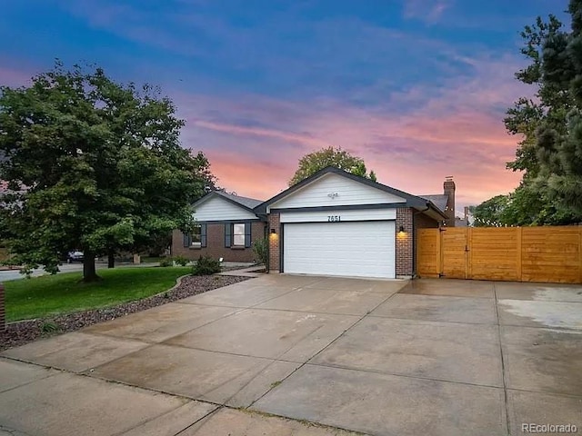 7651 Robb St, Arvada, CO 80005 - single story home with a garage, brick siding, concrete driveway, a chimney, and a gate
