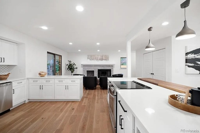 7651 Robb St, Arvada, CO 80005 - kitchen with stainless steel appliances, plenty of natural light, light wood-type flooring, white cabinetry, and recessed lighting