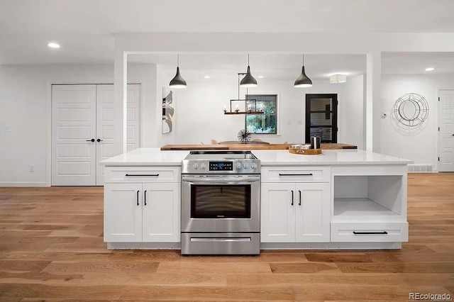 7651 Robb St, Arvada, CO 80005 - kitchen with electric range, white cabinetry, recessed lighting, and light wood-style flooring