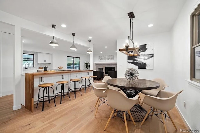7651 Robb St, Arvada, CO 80005 - dining area with light wood-style flooring, a fireplace, and recessed lighting