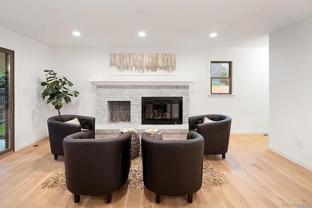 7651 Robb St, Arvada, CO 80005 - living room featuring wood finished floors, a brick fireplace, and recessed lighting